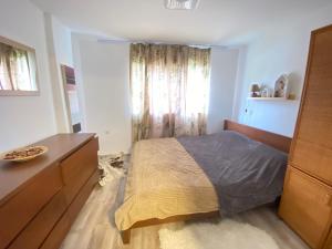 Un dormitorio con una cama y una cómoda y una ventana. en Mountain Heaven Apartment, en Kolašin