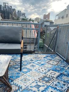 a balcony with a chair and a rug on a floor at FunNan Guesthouse in Tainan