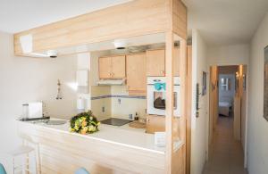 a kitchen with wooden cabinets and a counter top at Escale à deux au coeur de l'île de Ré - La Rétaise in Saint-Martin-de-Ré +6 photos