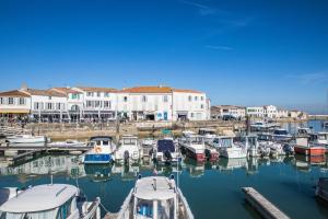 a group of boats docked in a harbor with buildings at Escale à deux au coeur de l'île de Ré - La Rétaise in Saint-Martin-de-Ré
