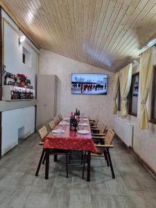 a dining room with a red table and chairs at Pensiunea Rares in Tălpăşeşti