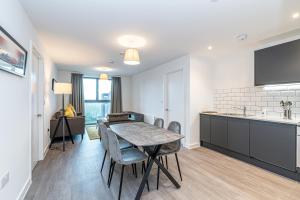 Insignia Apartments في مانشستر: مطبخ وغرفة طعام مع طاولة وكراسي
