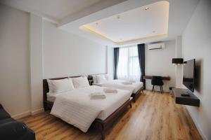 a bedroom with two beds and a desk in it at Play Poshtel & Cafe' in Krabi