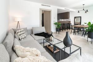 a living room with a gray couch and a table at GG- Modern townhouse, families & couples only in Marbella