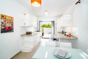 a kitchen with white cabinets and a table and chairs at EN- Cozy Andalusian style townhouse in Marbella in Marbella