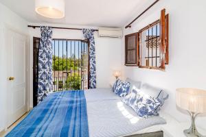 a bedroom with a blue and white bed and a window at EN- Cozy Andalusian style townhouse in Marbella in Marbella +29 photos
