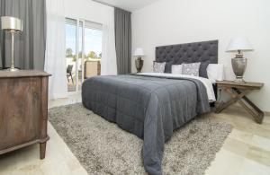 a bedroom with a large bed with a gray blanket at LBP- 3 Bedroom apartment with large roof top terrace in Marbella