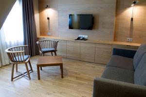 a living room with a couch and two chairs and a tv at Apartaments Vall de Núria in Queralbs