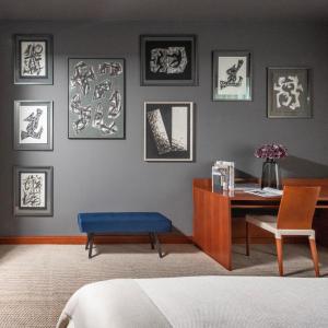 a bedroom with a desk and a blue bench and pictures on the wall at Art Hotel Prague in Prague
