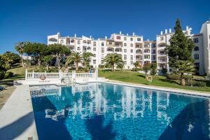 einem Pool vor einem großen weißen Gebäude in der Unterkunft RDM - Stylish Holiday Apartment with Ocean Views in Mijas