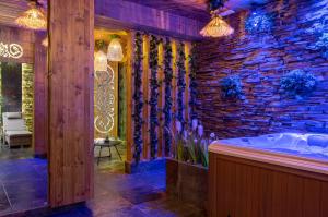 ザコパネにあるHotel Zakopane Wellness & SPA ex Korona Tatrの石壁のバスルーム(バスタブ付)