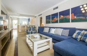 エステポナにあるHB Comfortable Beachfront Holiday Apartmentのリビングルーム(青いソファ、テーブル付)