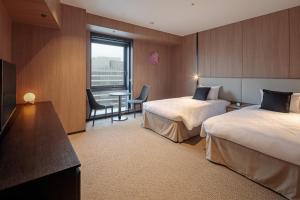 Postel nebo postele na pokoji v ubytování Yokohama Tokyu REI Hotel