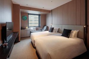 Postel nebo postele na pokoji v ubytování Yokohama Tokyu REI Hotel