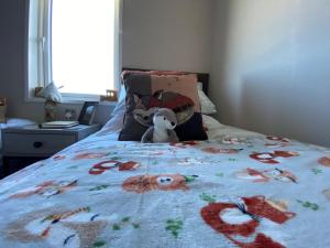 a stuffed teddy bear sitting on top of a bed at Mawgan Pads Padstow in Padstow