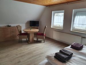ein Zimmer mit zwei Betten und einem Tisch und einem Fernseher in der Unterkunft Ferienhaus Trudi in Winterberg