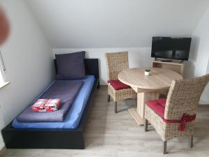 Cette chambre comprend un lit et une table avec des chaises. dans l'établissement Ferienhaus Trudi, à Winterberg