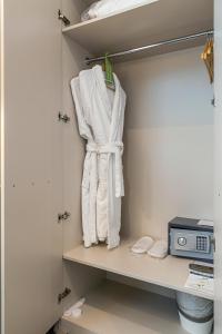 a closet with white towels hanging on a shelf at Europa Hotel and Apartment in Kaliningrad