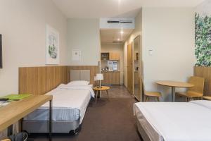 a hospital room with two beds and a table at Europa Hotel and Apartment in Kaliningrad