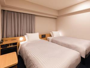 Postel nebo postele na pokoji v ubytování Sotetsu Fresa Inn Nagoya-Shinkansenguchi