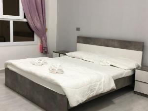 1 dormitorio con 1 cama grande con sábanas blancas en Sab Bani Khamis House en Sa‘ab Banī Khamīs