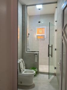 a bathroom with a toilet and a glass shower at Sab Bani Khamis House in Sa‘ab Banī Khamīs