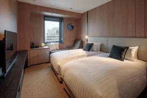 Postel nebo postele na pokoji v ubytování Yokohama Tokyu REI Hotel
