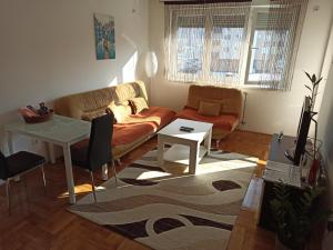 ein Wohnzimmer mit einem Sofa und einem Tisch in der Unterkunft BK Apartment, Istocno Sarajevo, Lukavica in Lukavica