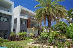 a house with a palm tree in front of it at Nautilya Apartment by LOV in Pointe aux Cannoniers