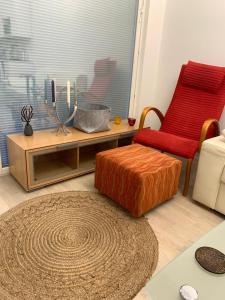 a living room with a red chair and a table at Modern Apartment nearby Airport in Vantaa