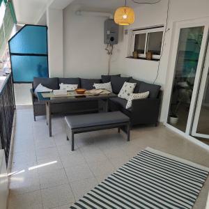 sala de estar con sofá y mesa en Sunny 3 bed beach flat - large terrace with sea view en Puerto de Sagunto
