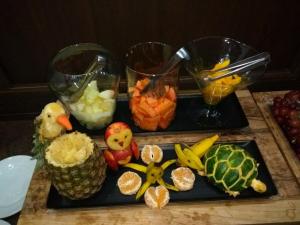 two black trays with fruits and vegetables on a table at Café Palace Hotel in Três Pontas