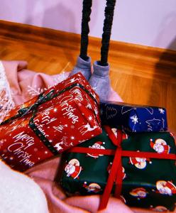 three wrapped presents sitting on top of a bed at Apartman Jela in Nova Varoš