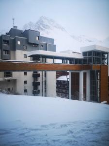 a building in the snow with a mountain in the background at Great 8-pax ski-in ski-out apartment in Tignes Val Claret in Tignes