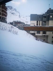 un cumulo di neve davanti ad alcuni edifici di Great 8-pax ski-in ski-out apartment in Tignes Val Claret a Tignes