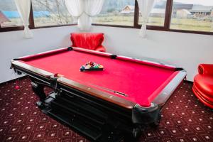 a red pool table in a room with a red chair at Pension Elegance in Gura Humorului