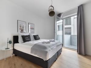 a bedroom with a large bed and a window at limehome Gütersloh Eickhoffstraße in Gütersloh