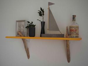 ein Holzregal an der Wand mit einer Flasche Whiskey in der Unterkunft Ferienhaus Segelbär in Hooksiel