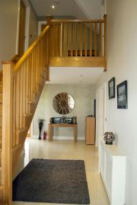 een hal met een houten trap met een tapijt bij Cahermaclanchy House B&B in Doolin