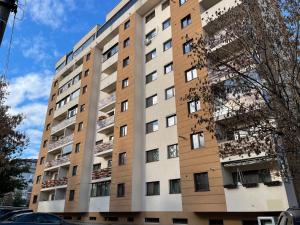 um edifício de apartamentos alto com muitas janelas em New Studio em Piteşti