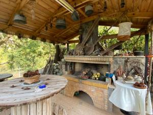 an outdoor patio with a stone fireplace and a table at Artemis Mezonetes in Kalavrita