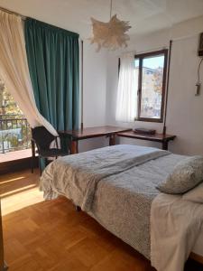 a bedroom with a bed and a desk and a window at NO FIESTAS, 5 DORMITORIOS Solo familias, parejas o trabajo PARKING Público Gratis a 300m in Toledo