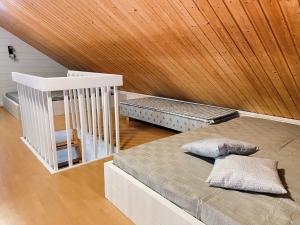a bedroom with two beds and a wooden ceiling at Lomasärkkä1 in Kalajoki