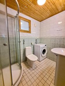 a bathroom with a shower toilet and a washing machine at Lomasärkkä1 in Kalajoki +14 photos