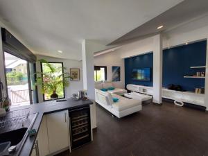 ein großes Wohnzimmer mit einem Sofa und einem Tisch in der Unterkunft Villa Pluton - Meublé de tourisme 4 étoiles in Saint-Gilles-les-Bains