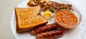 a plate of breakfast food with sausage beans and toast at Margarita House in Nairobi