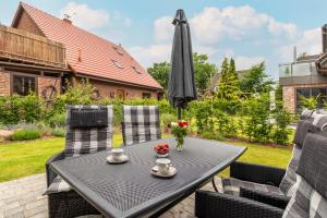 a table and chairs with an umbrella on a patio at Achterliek in Zingst