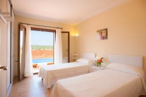 a hotel room with two beds and a large window at Finca Xorca in Caʼs Concos +42 photos