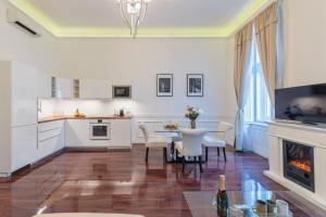 een keuken en eetkamer met een tafel en een open haard bij Music Academy Bedroom Suite Café Vian Apartman Kft in Boedapest
