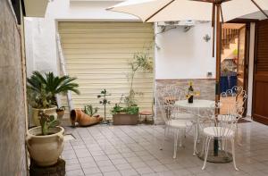 een terras met een tafel, stoelen en een parasol bij Daria’s home apartament in Palermo